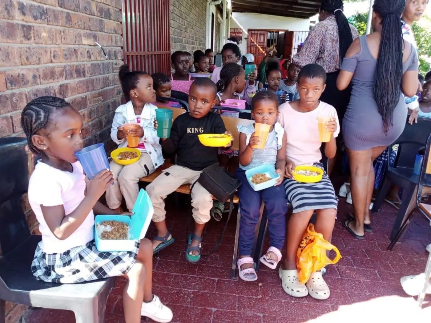 Children with lunchboxes after being served