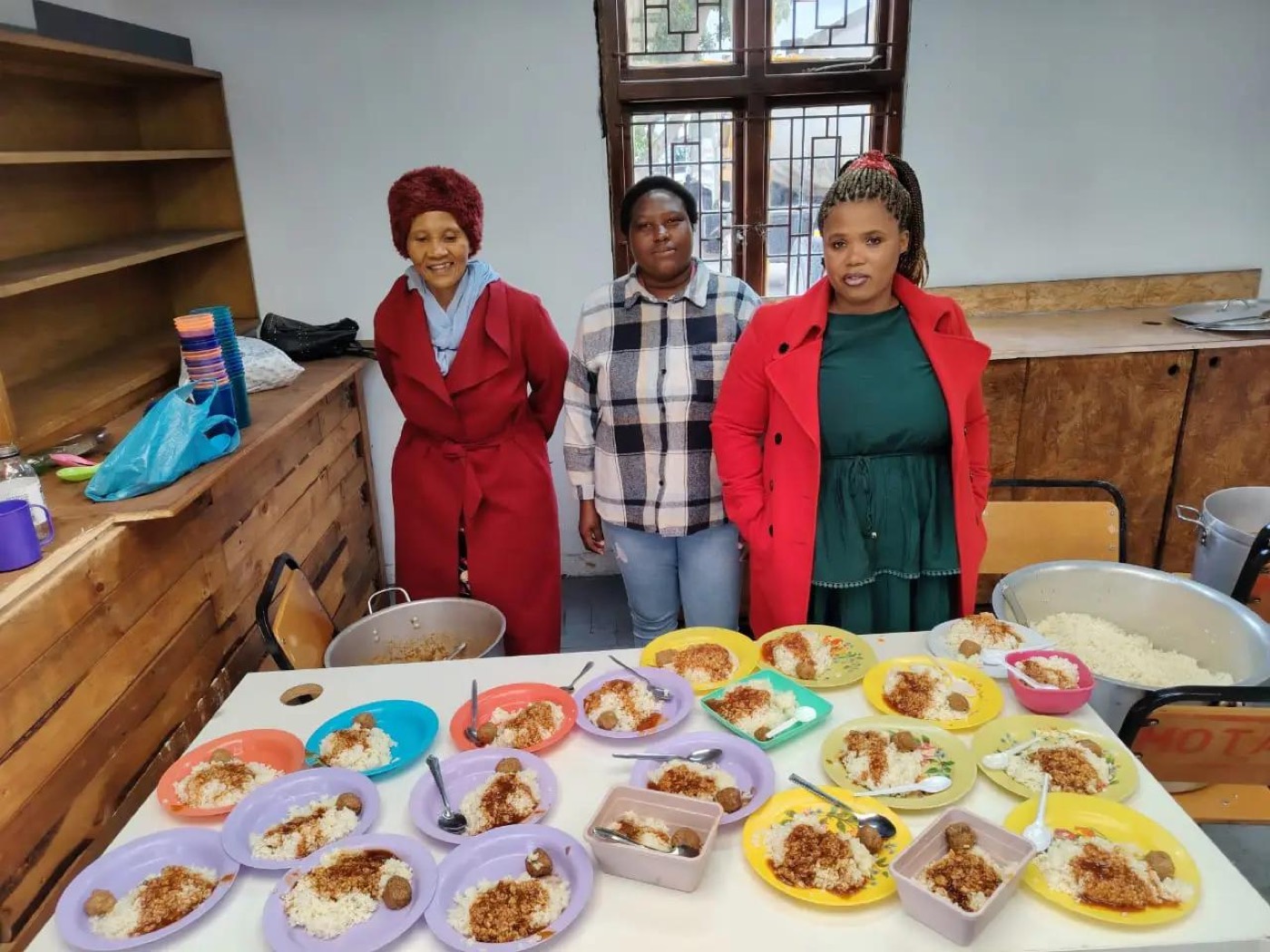 Inner City Mission volunteers with plated meals ready to serve